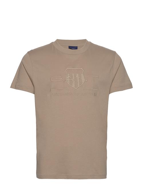 Se GANT Reg Tonal Shield Ss T-Shirt GANT Beige ved Booztlet