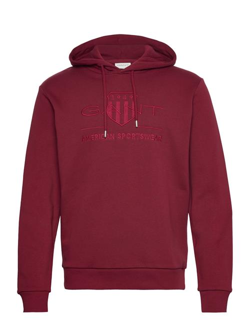 Se GANT Reg Tonal Shield Hoodie GANT Burgundy ved Booztlet